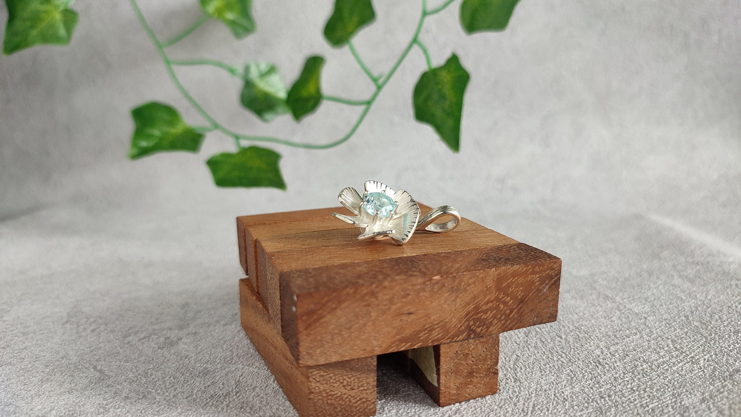 Spinning flower pendant with topaz