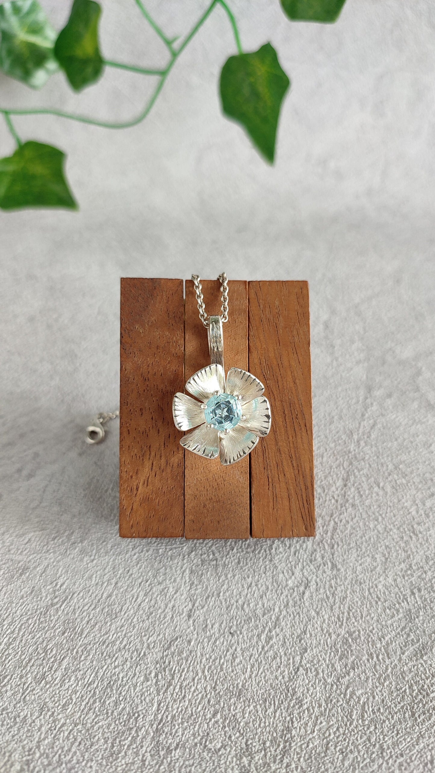 Spinning flower pendant with topaz